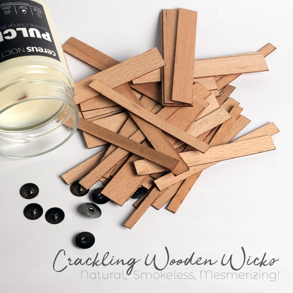 May include: A pile of natural wooden wicks for candles. The wicks are light brown and have a rough texture. The text "Crackling Wooden Wicks Natural, Smokeless, Mesmerizing!" is written below the pile of wicks.