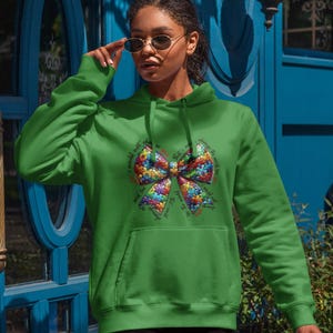 May include: Green hooded sweatshirt with a colorful puzzle piece bow and the text "I would'nt want it any other way, that's a world I choose to be a part of, different, unique, special, my strengths, my challenges, my world".