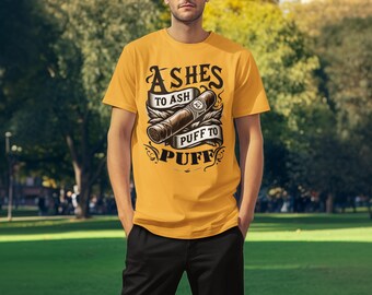 May include: A yellow t-shirt featuring a graphic design of a cigar and the text "Ashes to Ash Puff to Puff".