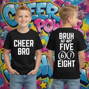 Op de afbeelding: Twee zwarte t-shirts met witte tekst. Eén shirt heeft "CHEER BRO" op de voorkant. Het andere shirt heeft "BRUH NO WAY FIVE 6 7 EIGHT" op de achterkant. De achtergrond is een kleurrijke graffiti-muur.