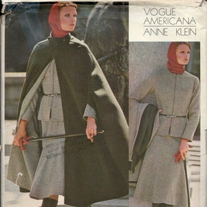 May include: A vintage Vogue Americana Anne Klein sewing pattern. The image features a model wearing a gray skirt suit with a matching cape and a red scarf. The text on the pattern reads "4" of the knit you choose should stretch to here only."