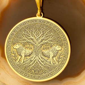 May include: Gold pendant necklace featuring a circular design with two wolves flanking a tree of life. The pendant is surrounded by runes and the chain is gold.