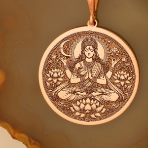May include: A copper necklace with a round pendant featuring an engraved image of a goddess sitting in a lotus position. The pendant is surrounded by intricate floral designs.
