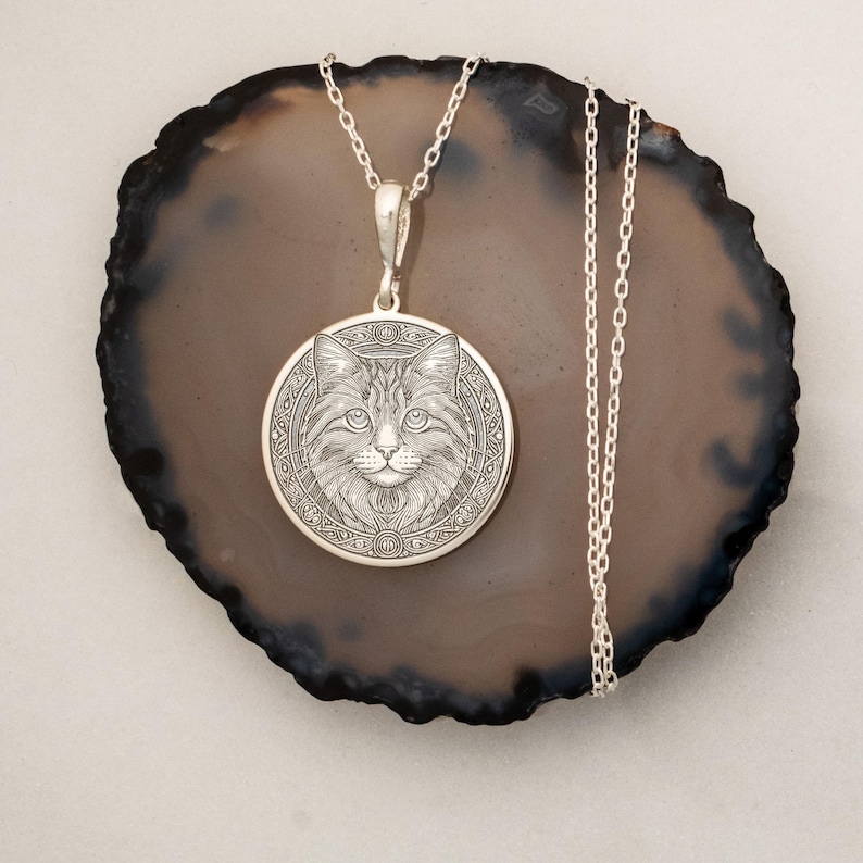 Gold-plated cat medallion necklace featuring a detailed feline with crescent moons, runes, and floral engravings, symbolizing intuition, independence, and mystical energy