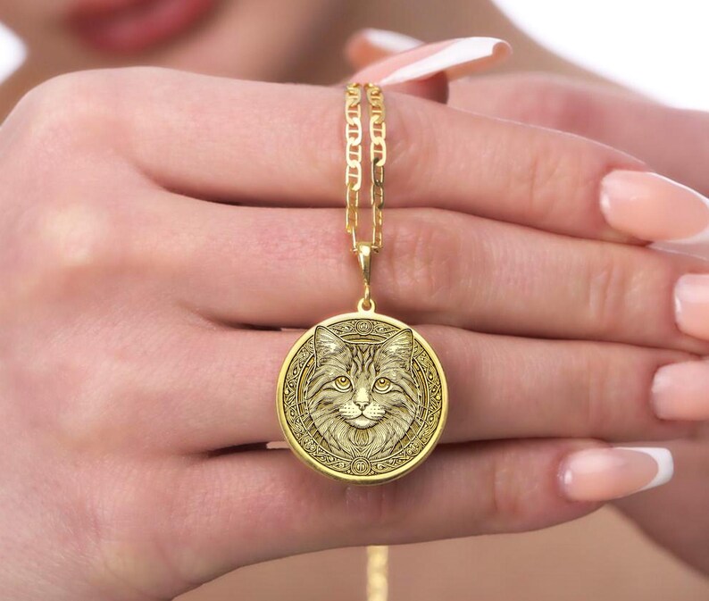 Gold-plated cat medallion necklace featuring a detailed feline with crescent moons, runes, and floral engravings, symbolizing intuition, independence, and mystical energy