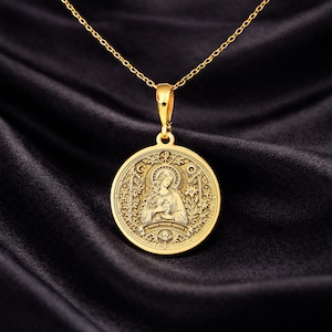Gold Mary Magdalene necklace featuring Byzantine-inspired Christian iconography with radiant halo, sacred vessel symbolism, Chi-Rho emblem, floral ornamentation, and devotional engraved details on circular medallion pendant. Religious jewelry inspired by Orthodox iconography, medieval illuminated manuscripts, Renaissance saint portrait traditions, and sacred feminine symbolism. Christian pendant representing spiritual devotion, divine grace, resurrection, contemplation, sacred memory.