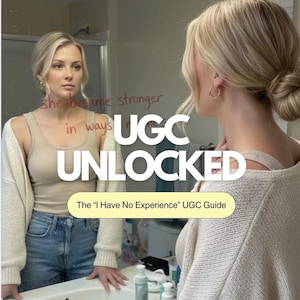 May include: A woman stands in front of a mirror with the text "She became stronger in ways" written on it. The mirror also displays the text "UGC UNLOCKED" and "The 'I Have No Experience' UGC Guide". She is wearing a beige tank top, a cream-colored cardigan, and blue jeans.
