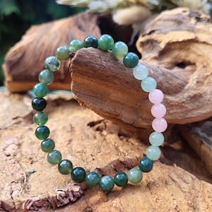 Op de afbeelding: Een groene en roze kralen armband met ronde kralen. De armband is gemaakt van natuurlijke stenen en is een mooi en uniek sieraad.