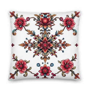 Puede incluir: Una almohada blanca con un estampado floral colorido. El diseño presenta un mandala central con tonos rojos, naranjas, amarillos, azules y verdes. El mandala está rodeado de motivos florales más pequeños en tonos rojos y rosas.