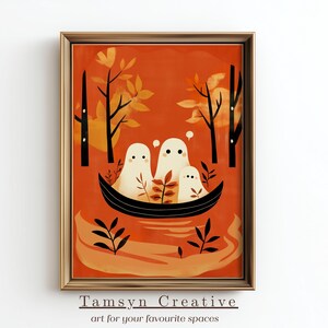 May include: A framed art print featuring three friendly ghosts in a boat, set against an orange background with stylized trees and foliage. The artwork has a warm color palette and a whimsical theme. The text "Tamsyn Creative art for your favourite spaces" is at the bottom.