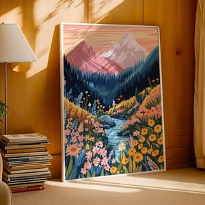 May include: A framed illustration of a mountain landscape with a stream running through a field of flowers. The mountains are pink and purple, and the flowers are yellow, pink, and blue.