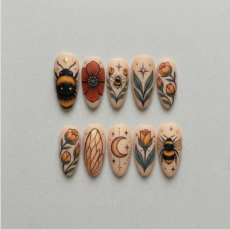 May include: A set of ten almond-shaped false nails with various designs. The designs include a bumblebee, a red poppy, a bee, a leaf, a flower, a gold wing, a crescent moon, and a star.