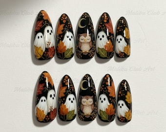 May include: Set of ten almond-shaped false nails with a Halloween theme. Each nail features a black base with autumn leaves, ghosts, and an owl design. The nails are decorated with orange, yellow, and white details.