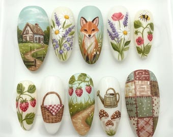 Könnte beinhalten: Ein Set aus zehn künstlichen Nägeln, die mit verschiedenen Naturmotiven bemalt sind. Die Designs umfassen ein Haus, einen Fuchs, Blumen, Erdbeeren, einen Korb, eine Gießkanne, Pilze und ein Patchworkmuster. Die Nägel sind oval und mit detaillierten Kunstwerken bemalt.