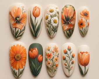 May include: A collection of ten oval-shaped artificial nails, each adorned with detailed floral designs. The nails feature various orange and white flowers, including daisies, tulips, and other blooms, set against a neutral background. The artwork showcases a range of styles.