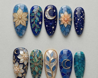 May include: A collection of ten intricately designed nail art samples. Each nail features a unique design, including floral patterns, celestial motifs with moons and stars, and mosaic-style backgrounds. The color palette includes blues, greens, and gold accents.