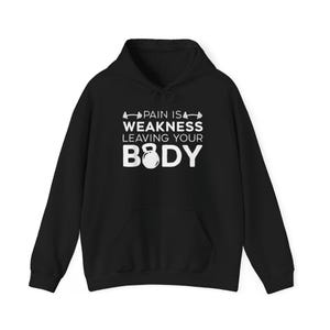 Könnte beinhalten: Schwarzer Kapuzenpullover mit Fronttasche und weißem Text: "PAIN IS WEAKNESS LEAVING YOUR BODY". Das Design zeigt eine Langhantel und eine Kettlebell. Bequeme Sportbekleidung.