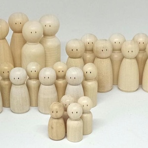 Könnte beinhalten: Ein Set aus Holz-Steckpuppen in verschiedenen Größen, alle mit einfachen bemalten Gesichtern. Die Puppen sind in einer Gruppe angeordnet, wobei die größten Puppen hinten und die kleinsten Puppen vorne stehen.