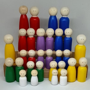 Könnte beinhalten: Eine Sammlung von Holzpuppen in verschiedenen Farben, darunter Rot, Blau, Grün, Gelb, Lila und Weiß. Die Puppen sind auf einem mehrstufigen Holzständer angeordnet, jede mit einem einfachen, abgerundeten Kopf und einem bemalten Körper.