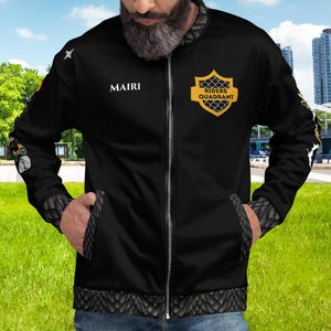 May include: Black bomber jacket with a zipper closure, featuring a yellow and black logo with the text "RIDERS QUADRANT" and the word "MAIRI" on the left chest.
