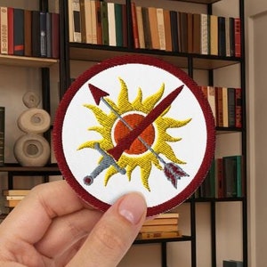 Parche bordado con el escudo de la Atlántida de Blood and Ash, accesorio literario de Poppy and Casteel