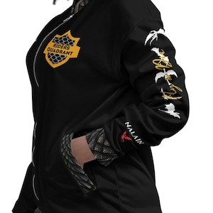 May include: A black zip-up bomber jacket featuring a yellow shield emblem on the chest with the text RIDERS QUADRANT. The sleeve displays white dragon silhouettes and the text Fly or Die, with NALAIN and a red dragon icon near the cuff.