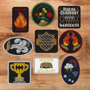 May include: A collection of nine embroidered patches featuring various designs including a flame with the text SECTION LEADER, a floral motif, a dragon emblem with RIDERS QUADRANT BASGIATH, a hand with wind, a shield, flames in hands, a trophy, a book with SCRIBES QUADRANT, and weather icons.
