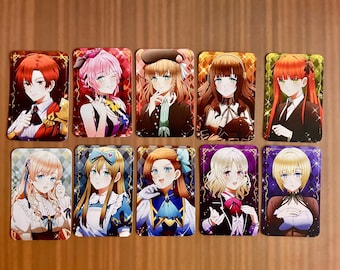 Puede incluir: Una colección de diez tarjetas coleccionables rectangulares con ilustraciones de personajes estilo anime. Cada tarjeta muestra a un individuo único con distintos colores de cabello, atuendos y expresiones, sobre fondos decorativos vibrantes con destellos.