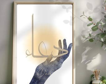 Puede incluir: Impresión artística enmarcada con una ilustración en acuarela de una mano que se extiende hacia arriba, con caligrafía árabe y la palabra "Dua" en cursiva. La mano es un degradado de azul y dorado, sobre un fondo blanco y amarillo.