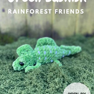 May include: A green basilisk plush toy with blue spots, lying on a bed of green moss. The text "Green Basilisk" and "Rainforest Friends" are at the top. A white circle with "DIGITAL PDF DOWNLOAD" is at the bottom.