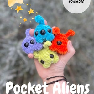 Può includere: Una mano mostra quattro peluche alieni all'uncinetto viola, blu, verde e arancione. Il testo "Pocket Aliens" e "Quick & No-Sew" è presente. È disponibile un download digitale PDF.