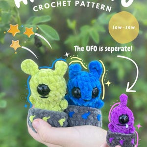 May include: A crochet pattern for Aliens + UFOs. The image shows three plush aliens in green, blue, and purple, each with a large black eye. The text "Aliens + UFO Crochet Pattern" is at the top. The UFO is separate.