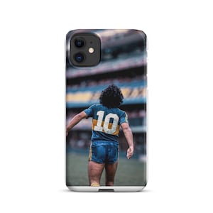 Puede incluir: Funda de teléfono con una foto de un futbolista con una camiseta azul y amarilla con el número 10 en la espalda. El jugador está en un campo verde, con un estadio al fondo.