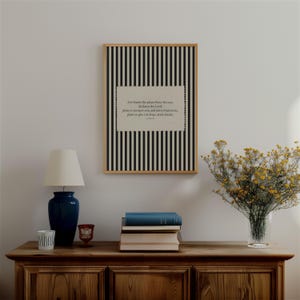 Könnte beinhalten: Ein gerahmter Druck mit einem schwarz-weiß gestreiften Hintergrund und einem beigen Rechteck mit Text. Eine marineblaue Lampe, Bücher und eine Vase mit gelben Blumen stehen auf einem Holzschrank. Der Text auf dem Druck lautet: "Denn ich weiß, welche Pläne ich für euch habe, spricht der HERR, Pläne, euch zu fördern und nicht zu schädigen, Pläne, euch Hoffnung und Zukunft zu geben."