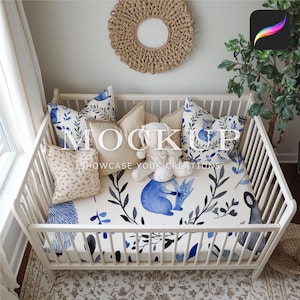 May include: White crib with a blue and white patterned fitted sheet. The sheet features a watercolor design of leaves, branches, and a small animal. There are several pillows on the crib, including a tan pillow with a brown and white pattern, a white pillow with a tan trim, and a blue and white patterned pillow.