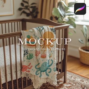 Op de afbeelding: Een wit wiegje met een crèmekleurige en witte deken met een octopus, schelpen en koraal. De deken heeft een franje rand en is over de wieg gelegd.