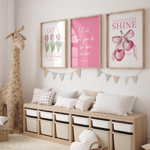 Pu&ograve; includere: Una scena di cameretta con opere d'arte incorniciate con citazioni e illustrazioni ispiratrici. Una grande giraffa tessuta &egrave; accanto a un mobile contenitore in legno con contenitori bianchi e beige. Cuscini e ghirlande decorative completano l'arredamento della stanza.