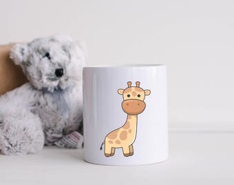 May include: White ceramic mug featuring a cartoon giraffe illustration. The giraffe is light brown with dark brown spots and has a friendly expression.