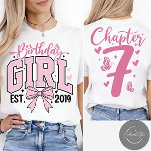 May include: White t-shirt with pink text and graphics. The front reads "Birthday GIRL EST. 2019" with a bow and butterfly. The back says "Chapter 7" with hearts and butterflies. A birthday-themed shirt.