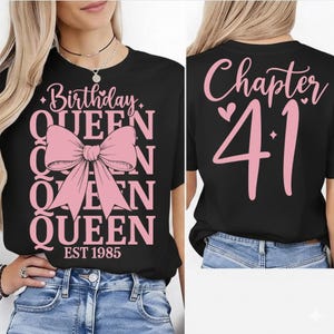 Puede incluir: Camiseta negra con texto rosa y un gran lazo rosa. La parte delantera de la camiseta dice "Birthday QUEEN" con "EST 1985" debajo. La parte trasera de la camiseta dice "Chapter 41".