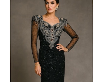 Puede incluir: Vestido de noche negro con mangas largas y transparentes y escote cuadrado. El corpiño está ricamente adornado con intrincados abalorios en oro, plata y azul oscuro. El vestido tiene una silueta ajustada y un sutil estampado de puntos.