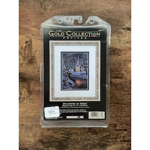 Puede incluir: Un kit de punto de cruz contado Dimensions Gold Collection Petites titulado Splendor at Night, que muestra una escena de iglesia invernal con ciervos. El kit incluye tela Aida azul marino de 18 count, aguja, hilo y gráfico para un diseño de 13 cm por 18 cm.