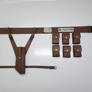May include: A brown leather utility belt with six pouches, a holster, and suspenders. The belt has a silver buckle and a black section on the end. The text "BELTEDSTORE" is printed on the belt.