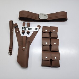 May include: A brown leather belt with a silver buckle, a holster, a shoulder strap, and multiple pouches. The text "BELTEDSTORE" is visible on a white sign.