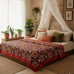 Puede incluir: Una habitación con una cama cubierta por un edredón vibrante con un diseño geométrico en rojo, amarillo, negro y blanco. La cama está adornada con almohadas de diferentes colores y texturas. La habitación está decorada con plantas y obras de arte enmarcadas.