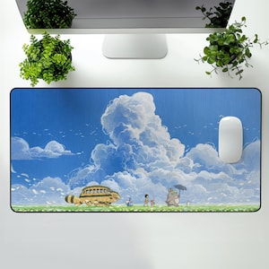 May include: A rectangular mousepad featuring a whimsical illustration of a blue sky with fluffy white clouds and a grassy field. The design includes animated characters and a yellow bus-like vehicle. A white mouse is on the right.