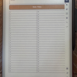 May include: A digital tablet displaying a lined page with the title "Note Titles" and numbered lines. The tablet has a stylus attached and a decorative border at the top. The page number is 2 of 522.