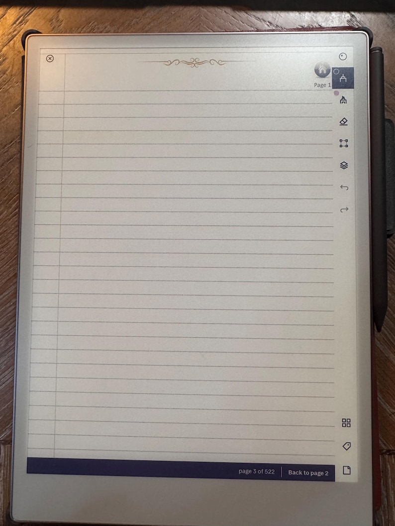 May include: A digital notepad with a lined page displayed. The screen shows the text "page 3 of 522" and "Back to page 2". A stylus is attached to the side. The notepad has a dark border and is on a wooden surface.