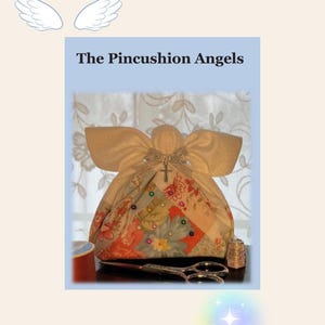 以下が含まれることがあります： パッチワークのデザインが施された手作りのピンクッションエンジェル。金色のリボンと十字架で飾られています。ハサミ、指ぬき、糸巻きなどの裁縫道具がピンクッションを囲んでいます。「The Pincushion Angels」の文字が表示されています。