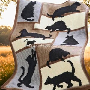 May include: A handmade crochet blanket featuring black cat silhouettes on a patchwork design. The blanket has a neutral color palette with squares of cream, gray, and brown. The blanket is edged with a brown border. The text "bessiavintagcollection" is visible.